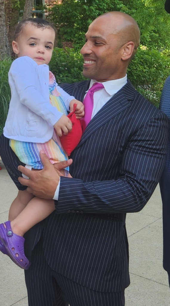 Clinton Graham holding his daughter Vivienne outdoors